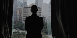 慢镜头剪辑的女人打开窗帘的观点，香港，中国