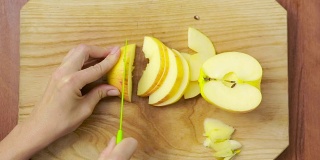 女人在木板上切苹果。烹饪食物。俯视图