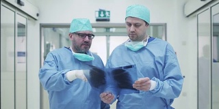 两位医生在医院里聊天。手里拿着平板电脑。