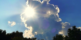 明亮的阳光光线显示后面的大白云在蓝天的背景