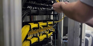 IT工程师检查打开的服务器机架，并插入电缆