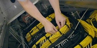 手放置一个黄色的以太网电缆在机架中