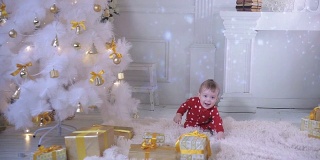 宝宝在圣诞树旁带着礼物探索新年礼物和圣诞树