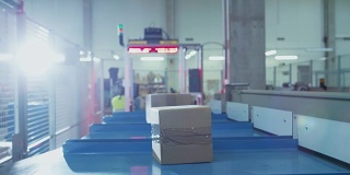 邮递分拣局的包裹正由传送带传送机传送。盒子观点。