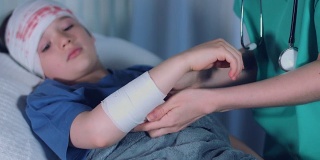 4k医院拍摄的一个生病的孩子，医生在受伤的手臂上敷绷带