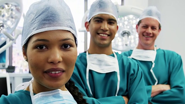 外科医生和护士双手交叉站在手术室的肖像