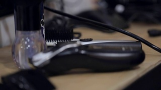 理发师在黑手套从一个完整的工具板上拿电动剃须刀和梳子。视频素材模板下载