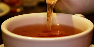 将红茶从茶壶中倒入杯中并搅拌