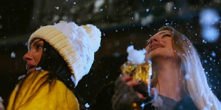 一群迷人的少女在户外庆祝。女性朋友们在玩，在雪地里跳舞。60帧/秒的慢动作