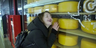 在陈列柜里拿着奶酪的女孩