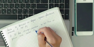 女人的手用钢笔在纸笔记本上做笔记