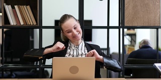 庆祝成功，兴奋的商务女性在笔记本电脑上工作