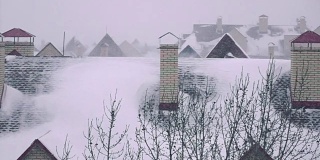 超级慢镜头拍摄冬季住宅倾斜屋顶上的暴风雪