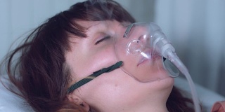 4k医院拍摄的带氧气面罩吸入烟雾的女病人