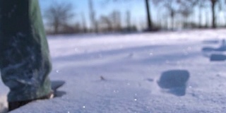 一个人的脚在雪山上行走的特写。慢动作拍摄