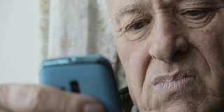 一位老人正在尝试使用一款带有触摸屏的新手机