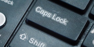 一个手指按键盘上“大写锁定”的极端特写