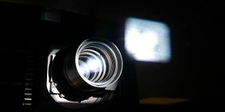 电影放映机镜头，动力光束透过玻璃和光学照射