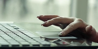 Close Up of a Female Hand Using a Laptop in a Cafe Near the Window .一个女性用笔记本电脑的近距离镜头