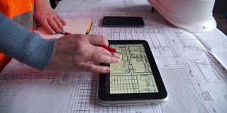 土木工程师使用平板电脑和施工计划