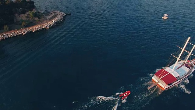 鸟瞰图的一艘大船拖着一艘船在海湾与深蓝色的水在日落，在4K超高清拍摄