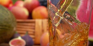 把苹果汁倒进玻璃杯里。缓慢的运动。