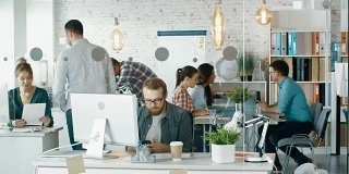 忙碌的创意办公室的时间流逝。办公室里用个人电脑工作的人，打电话的人，到处走动的人在会议桌上正在进行商务讨论。
