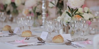 为婚礼或周年纪念招待会设置的节日餐桌烛台和鲜花靠近浅景深的场垂直锅。为几位客人安排餐具