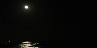 夜晚满月只在海上倒影，假日或旅行背景