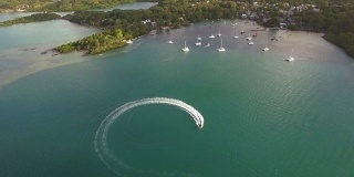 飞过在毛里求斯岛海湾行驶的摩托艇