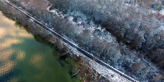 雪地里的铁路天线，紧挨着湖和树