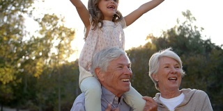 爷爷奶奶在公园里肩膀上骑孙女