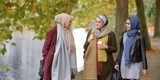 英国穆斯林女性朋友在城市的河边散步
