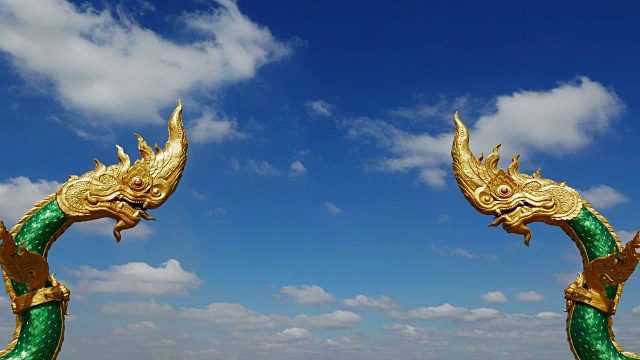 泰国那空番龙像面对面。那迦，保护的象征。时间流逝，移动的云映衬着清澈的蓝天。