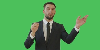 一个商人做滑动和触摸手势，而站在一个绿色屏幕背景。