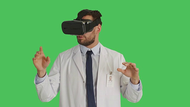 一个戴着VR头盔的科学家的中景。镜头围绕着他旋转。背景为绿幕。