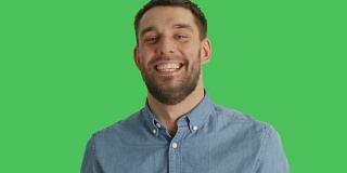 一个英俊的男人笑的中特写镜头。拍摄在一个绿色屏幕背景。
