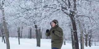 一名男子从公园的树枝上扔下雪