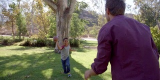 男孩和他的爸爸在公园里玩美式足球