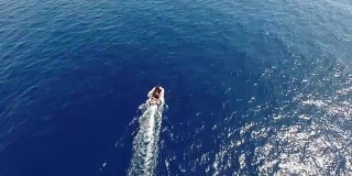 航拍:汽艇在蓝色的海面上起航
