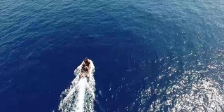 航拍:摩托艇驶过蓝色海面，留下白色的痕迹
