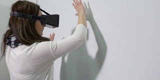 女性使用虚拟现实眼镜进入虚拟现实世界，并在交互式白板上写字