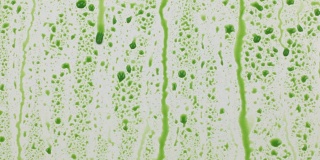 绿色的颜料滴落在白色的表面，形成小溪