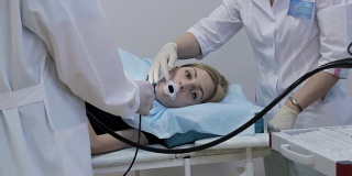 医生把内窥镜放进女孩的嘴里是一种医疗器械