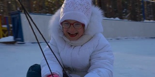 小女孩骑着雪橇。女孩很喜欢坐雪橇。女孩笑着和表情从快速滑雪橇。冬天孩子们的娱乐。