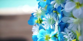 蓝色和白色的人造花阿罗哈挂在热带泳池旁