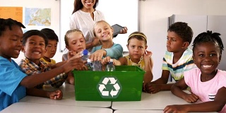学校的孩子们把废瓶子放在教室的回收箱里
