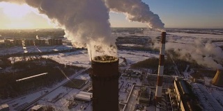 冒烟的烟囱发电厂的背景在冬天日落。鸟瞰图