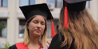 两个年轻的女毕业生在毕业典礼后讨论未来的计划