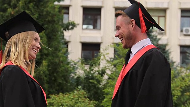 毕业典礼上，最好的朋友们穿着学位服，戴着学位帽，拥抱着，微笑着